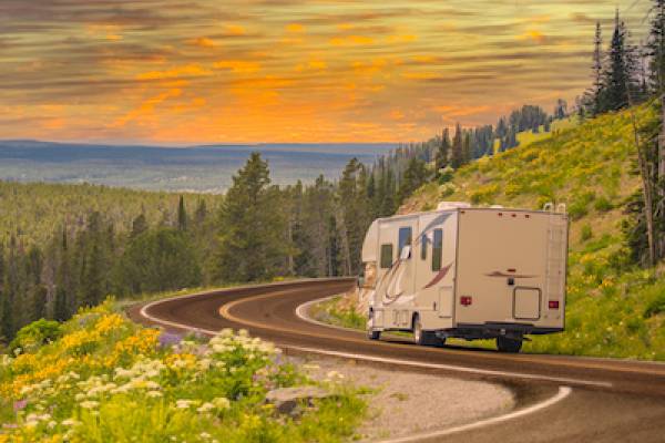 RV on winding mountain road at sunset